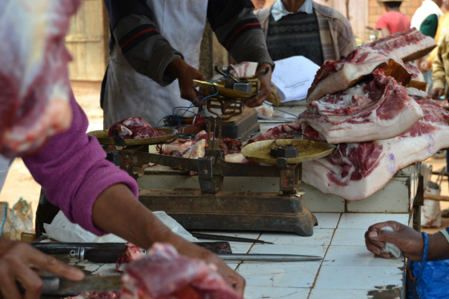 Butchers cutting pork in an open market in Madagascar