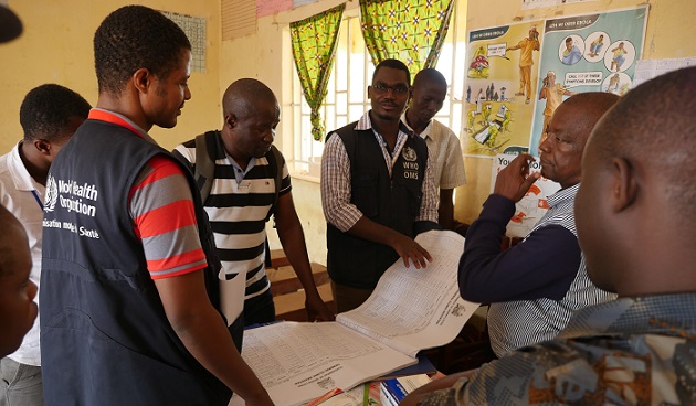 Dr Patrick Otim, WHO Emergency Preparedness and Response Team Lead assesses health records of the Kania Community Health Centre, Kambia district, Sierra Leone.