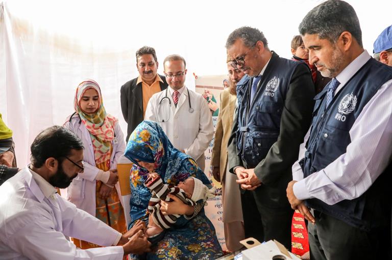 Dr Tedros Adhanom Ghebreyesus, WHO Director-General, watching a baby in Pakistan getting vaccinated against polio