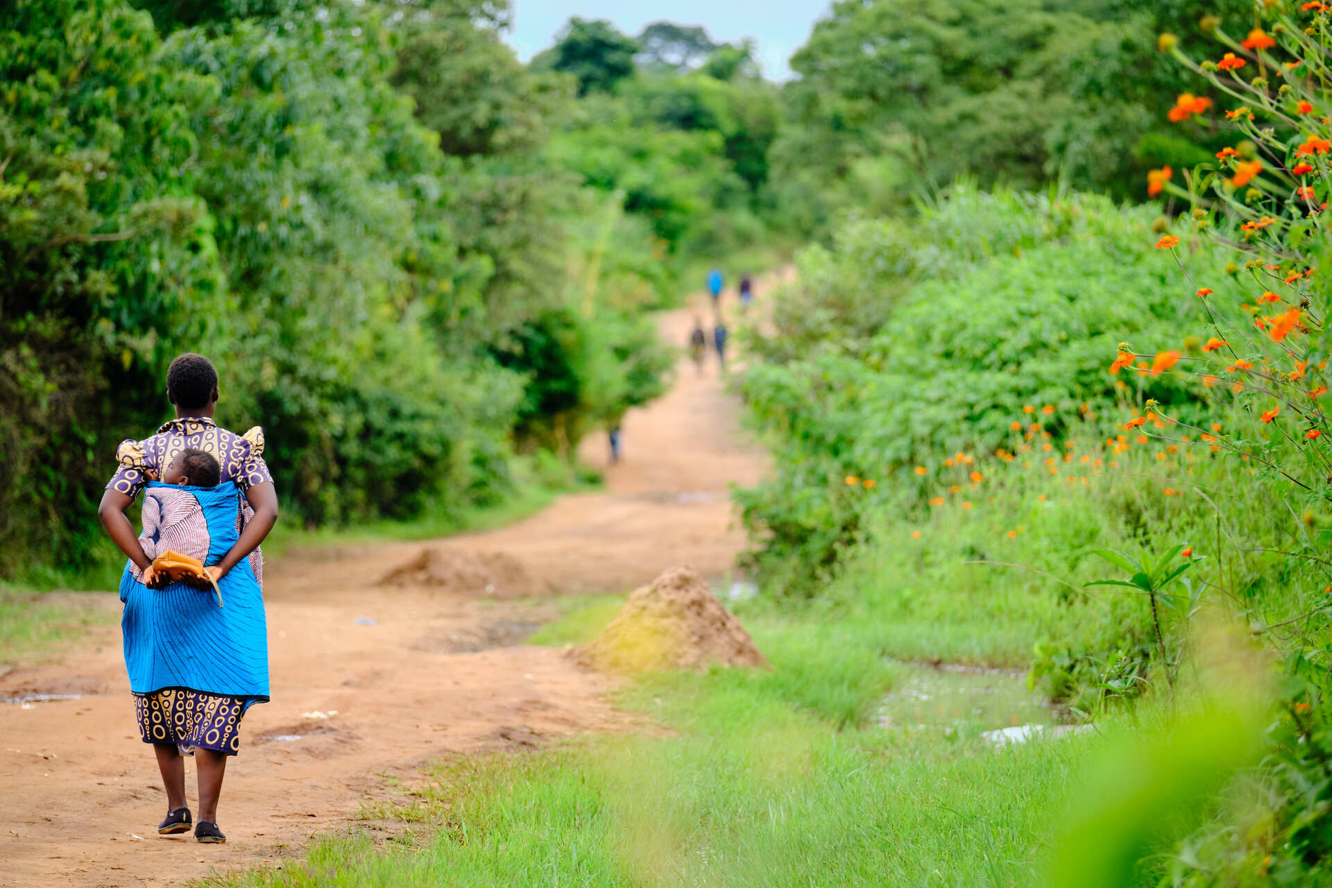A mother carries her child for a malaria vaccine implementation visit in Lilongwe, Malawi