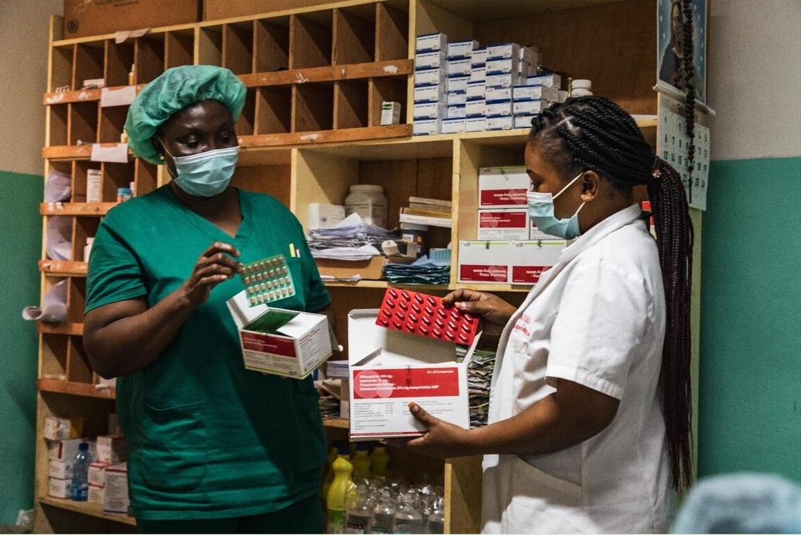 An image depicting a pharmacy where a nurse and a pharmacist verifies the stock of medicine.