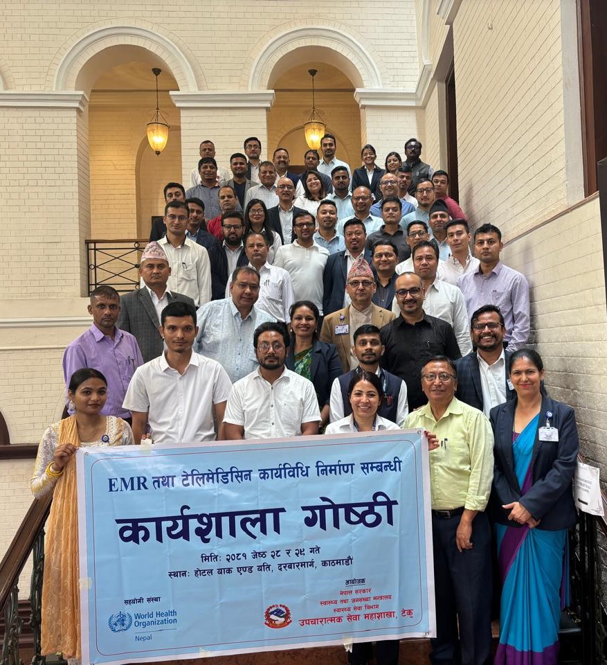 A group photo of the participants from the consultative workshop on Electronic Health Records and Telemedicine, holding the banner, in Bagmati province, Nepal