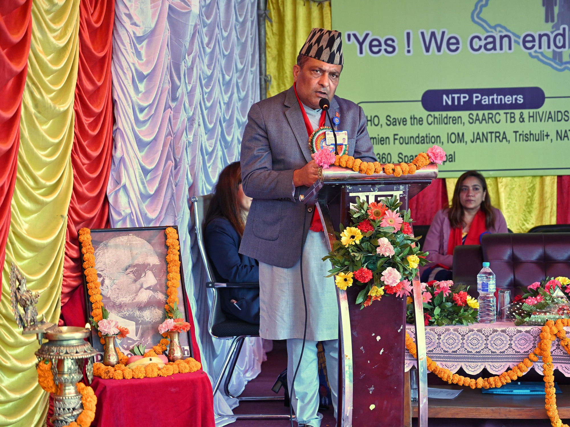 Hon’ble Secretary of the Ministry of Health and Population, Dr Roshan Pokhrel, providing his remarks on a podium at the commemoration of World Tuberculosis Day 2024 in Bagmati Province, Nepal