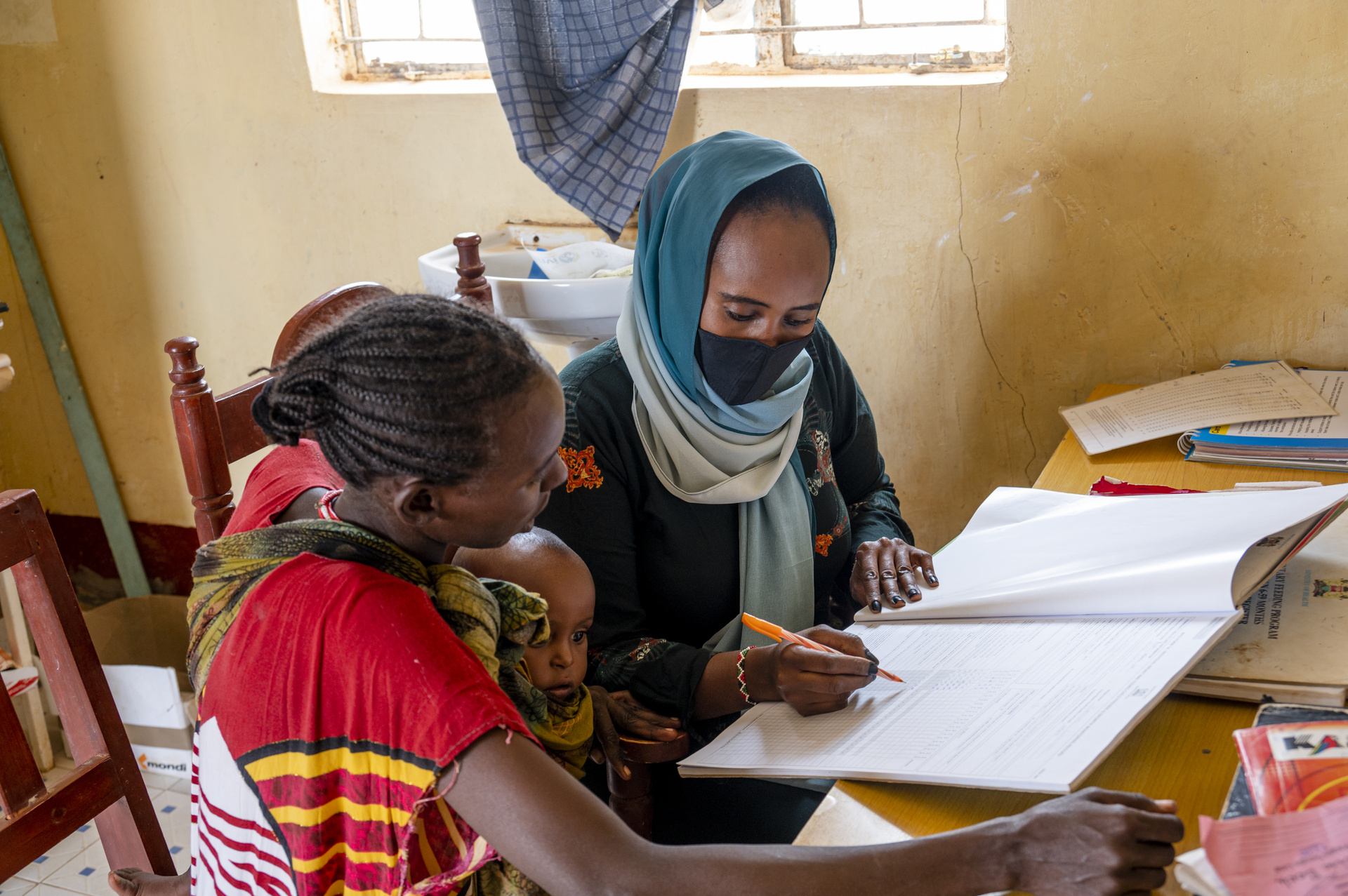 A community health worker going through nutrition records with her patient