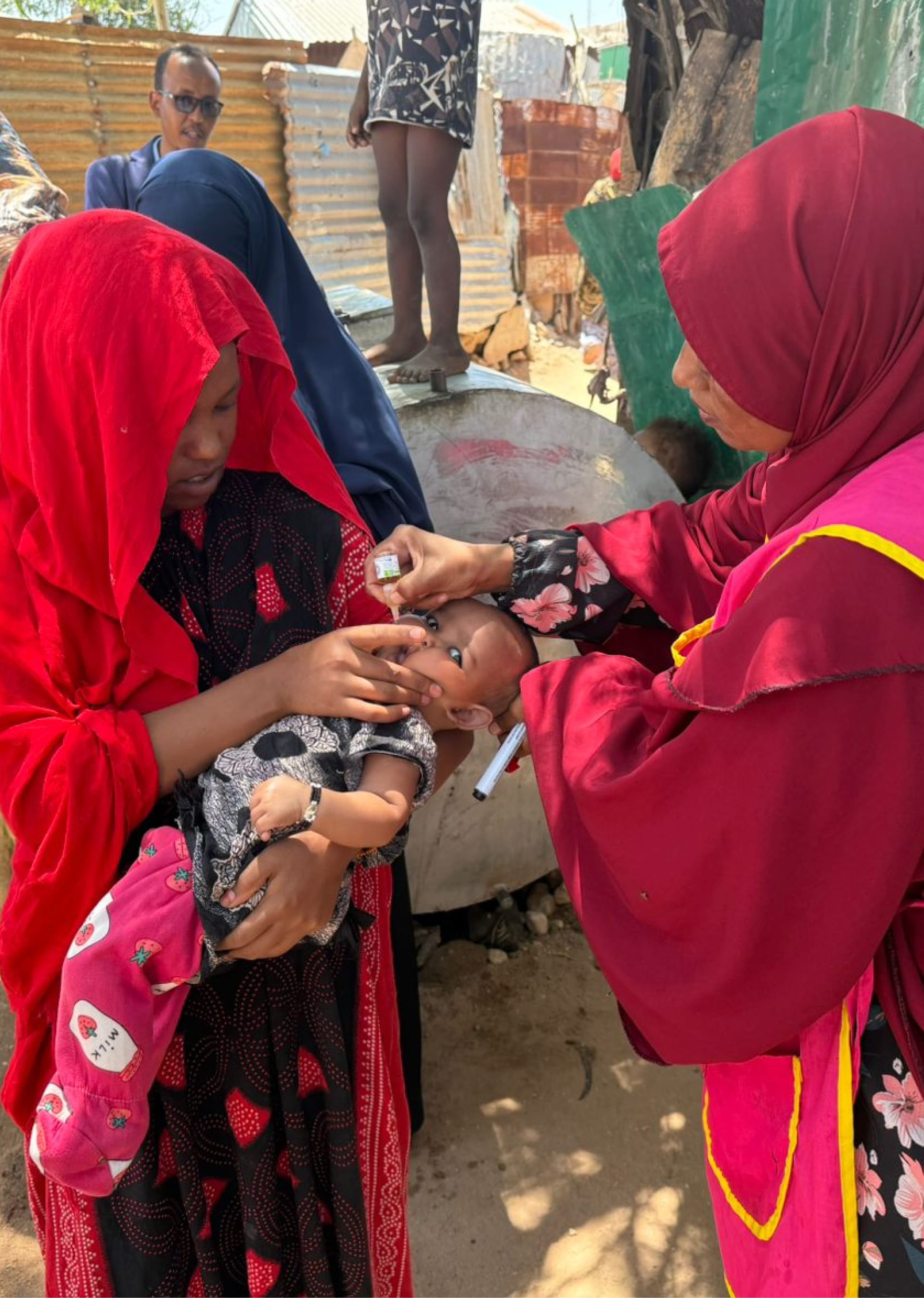 Somali Health worker administers polio vaccine to a young child.