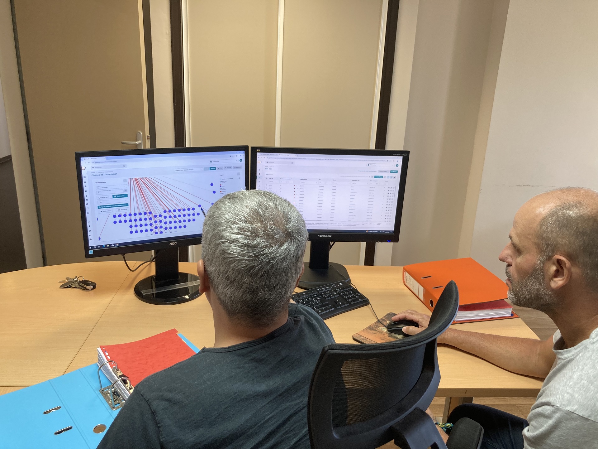 Two men look at a computer