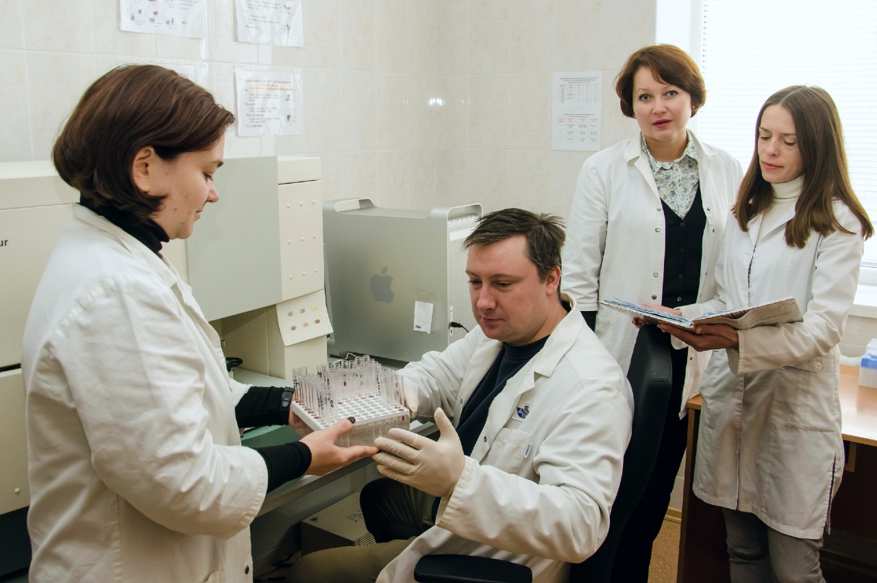 Laboratory personnel discussing leukemia phenotype studies.