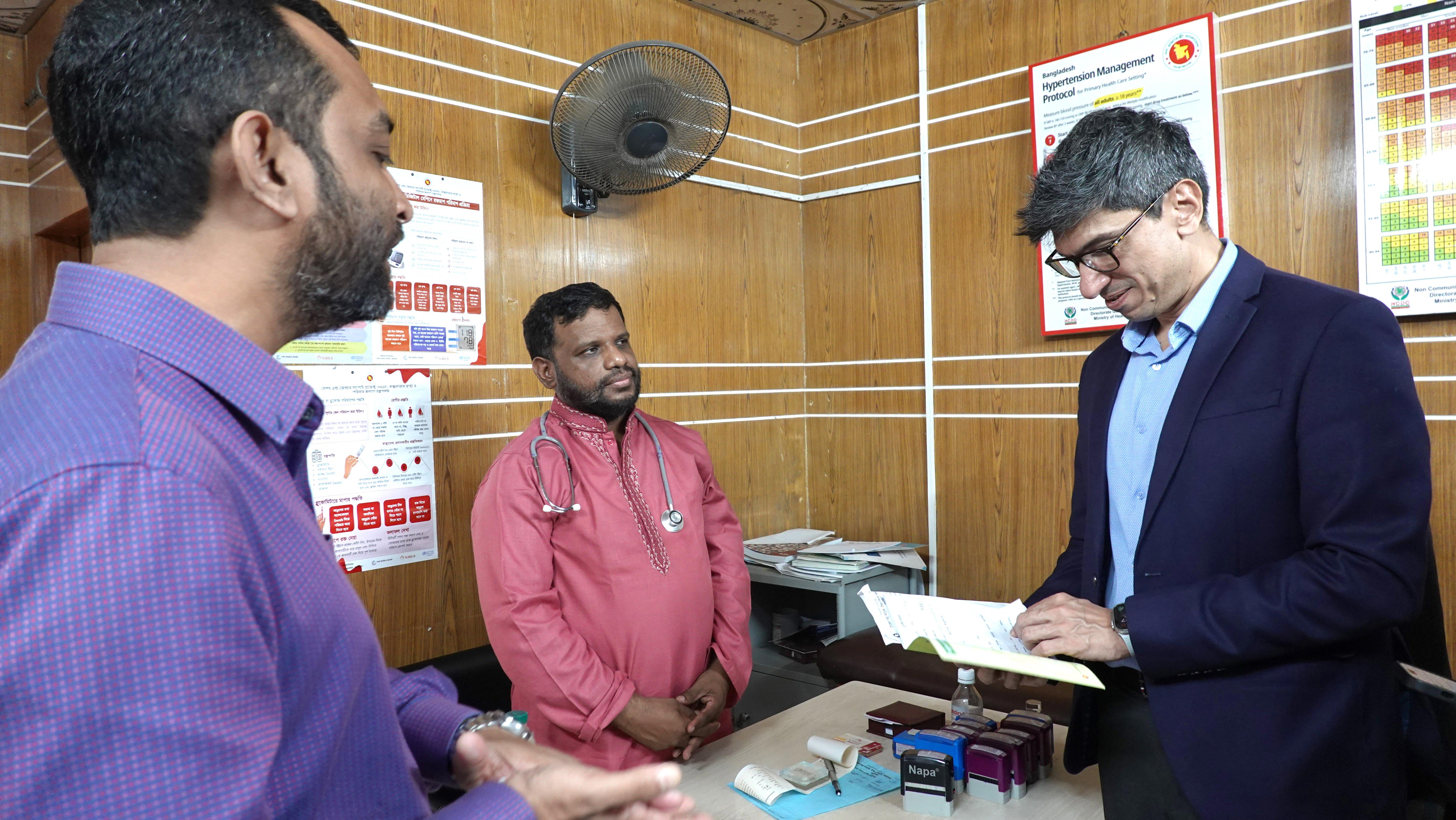 The Deputy WHO Representative inspects a patient’s NCD (Non-Communicable Disease) card, ensuring proper data management for improved healthcare delivery.