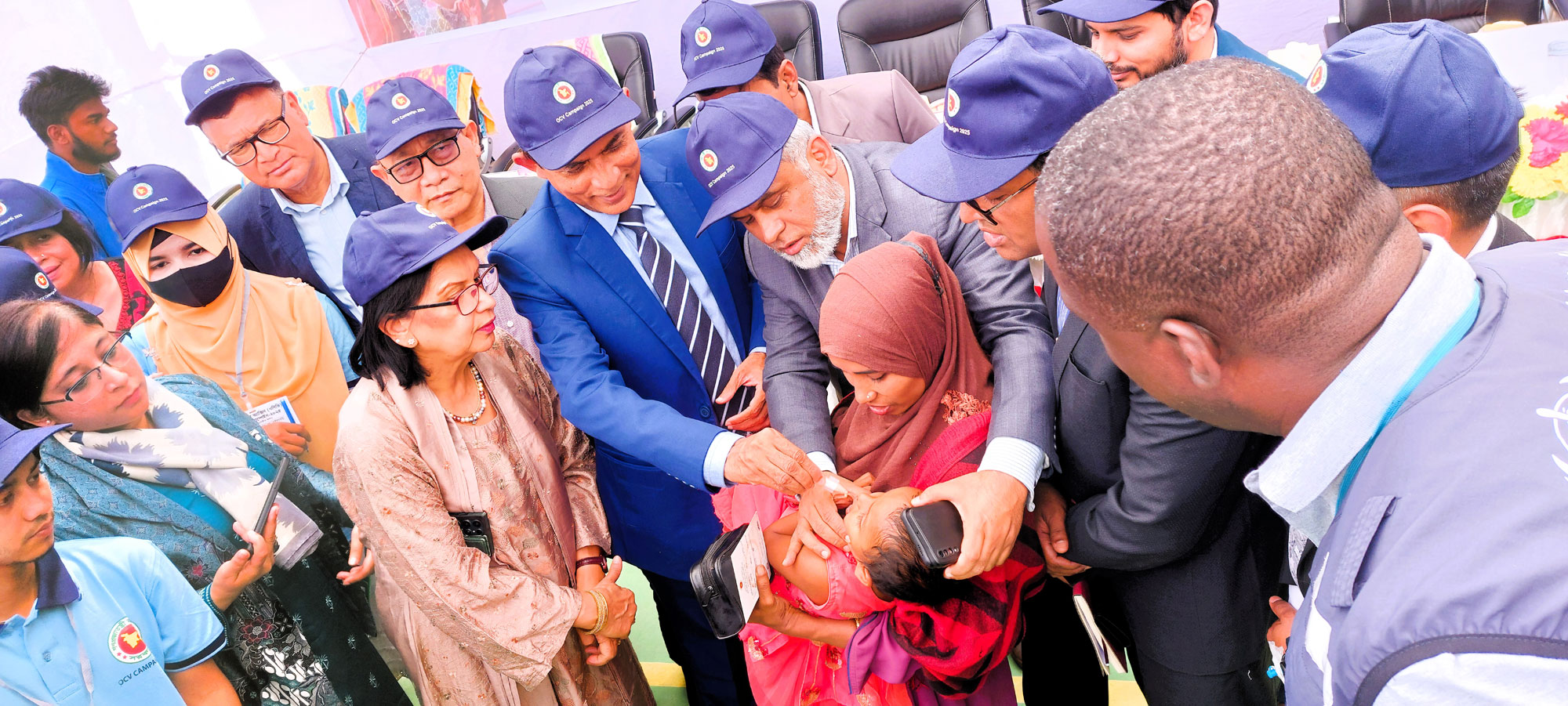 The Additional Secretary (Public Health Wing), with support from the Director (MIS), DGHS, administers the first OCV vaccine to an infant in Camp 04