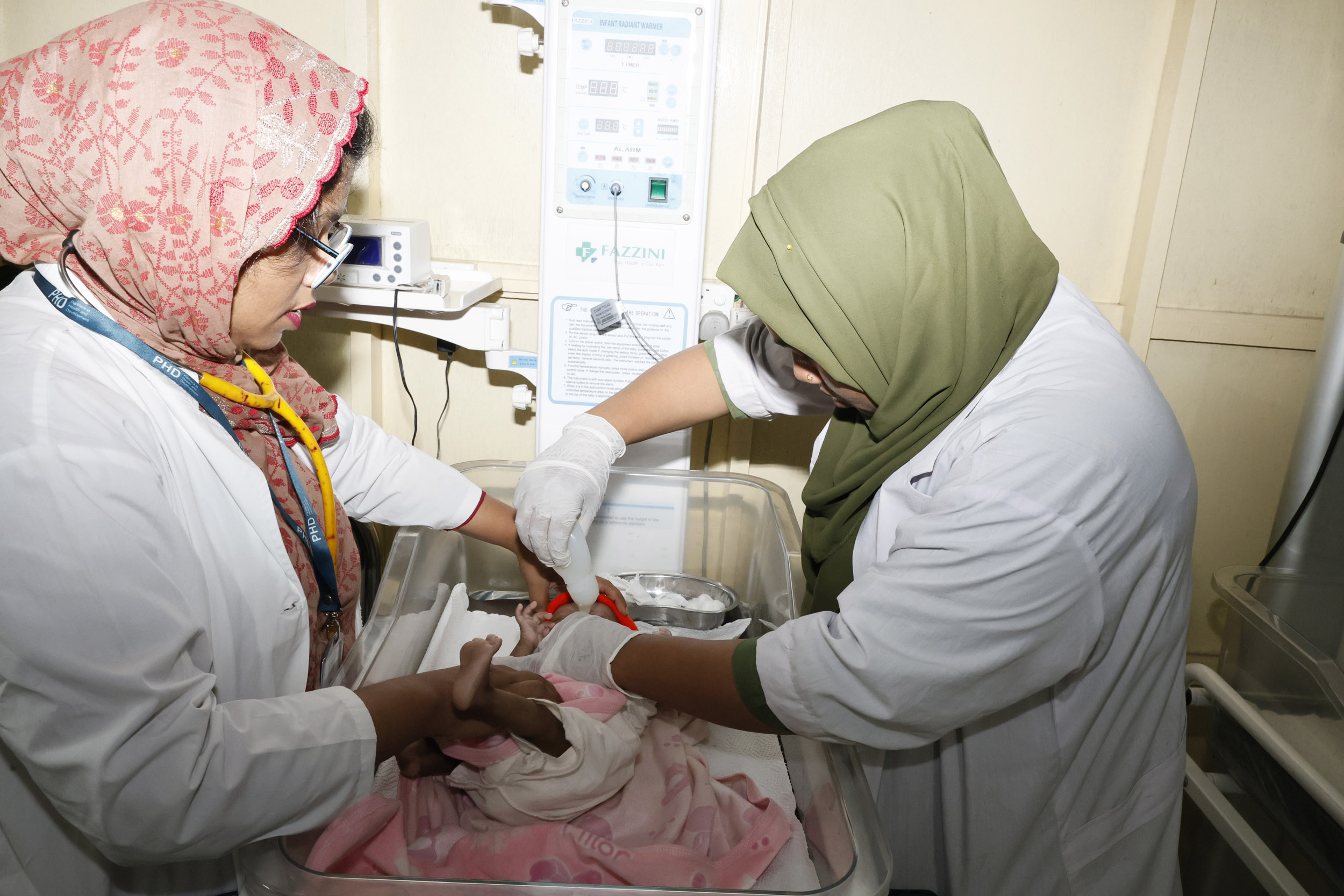 Dr Abida, assisted by colleague, applies her new skills to care for a newborn