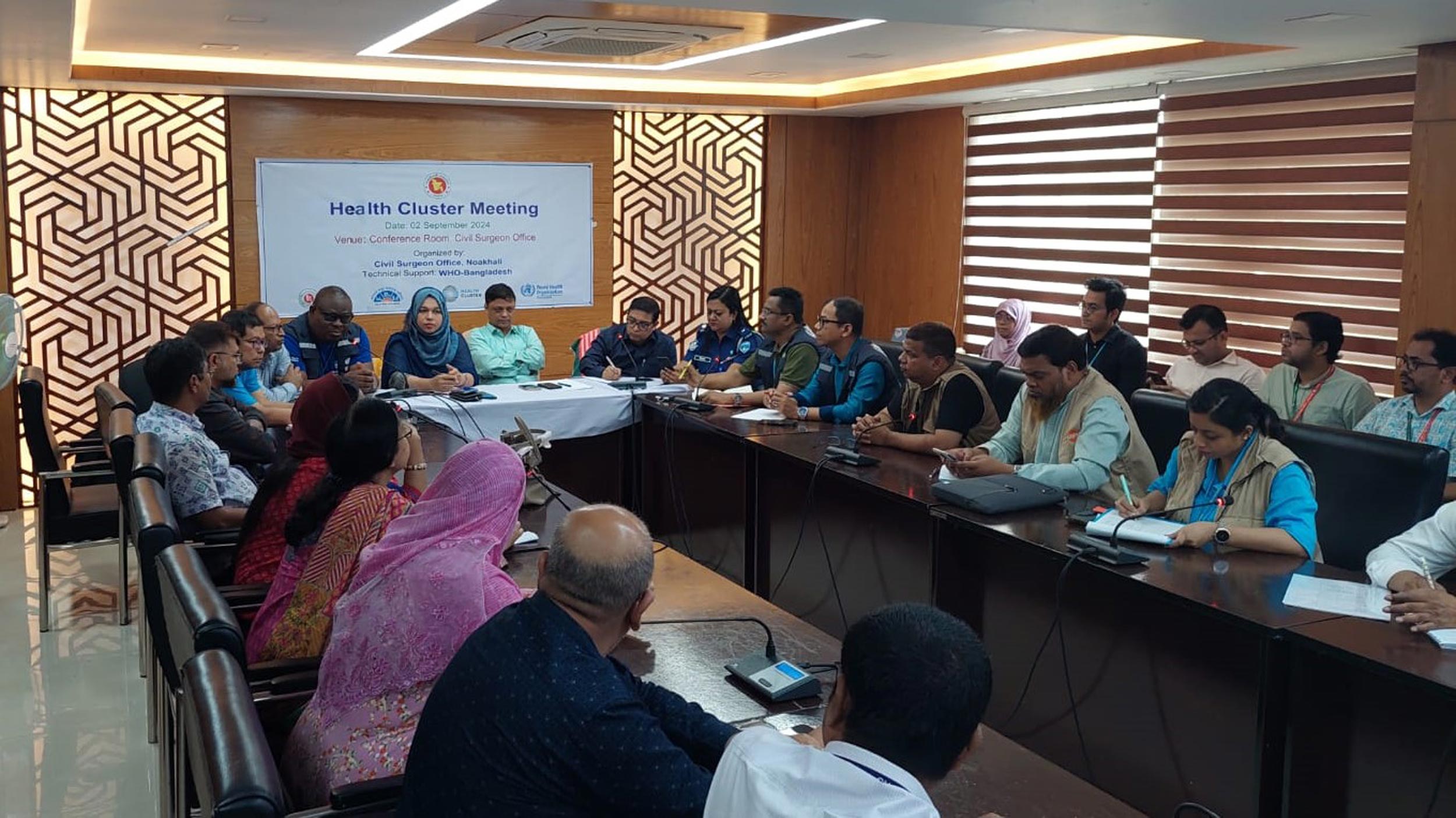 Representatives from WHO, local health authorities, and other partners convene at Noakhali District Civil Surgeon Office for a Health Cluster Meeting, coordinating urgent health interventions to mitigate the impact of the devastating floods on communities