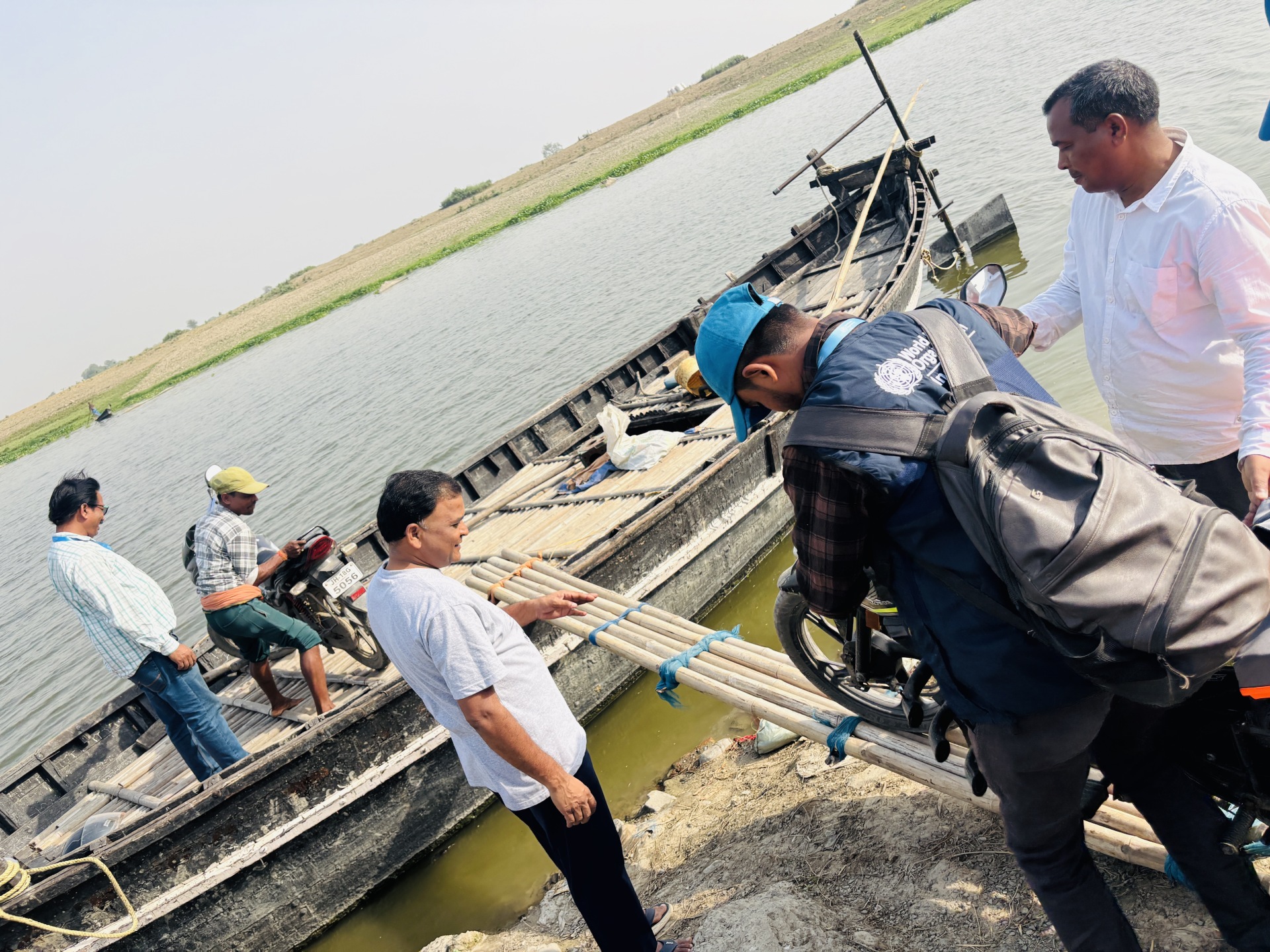 A WHO-National Public Health Support Network team loading their mobikes on a rowboat