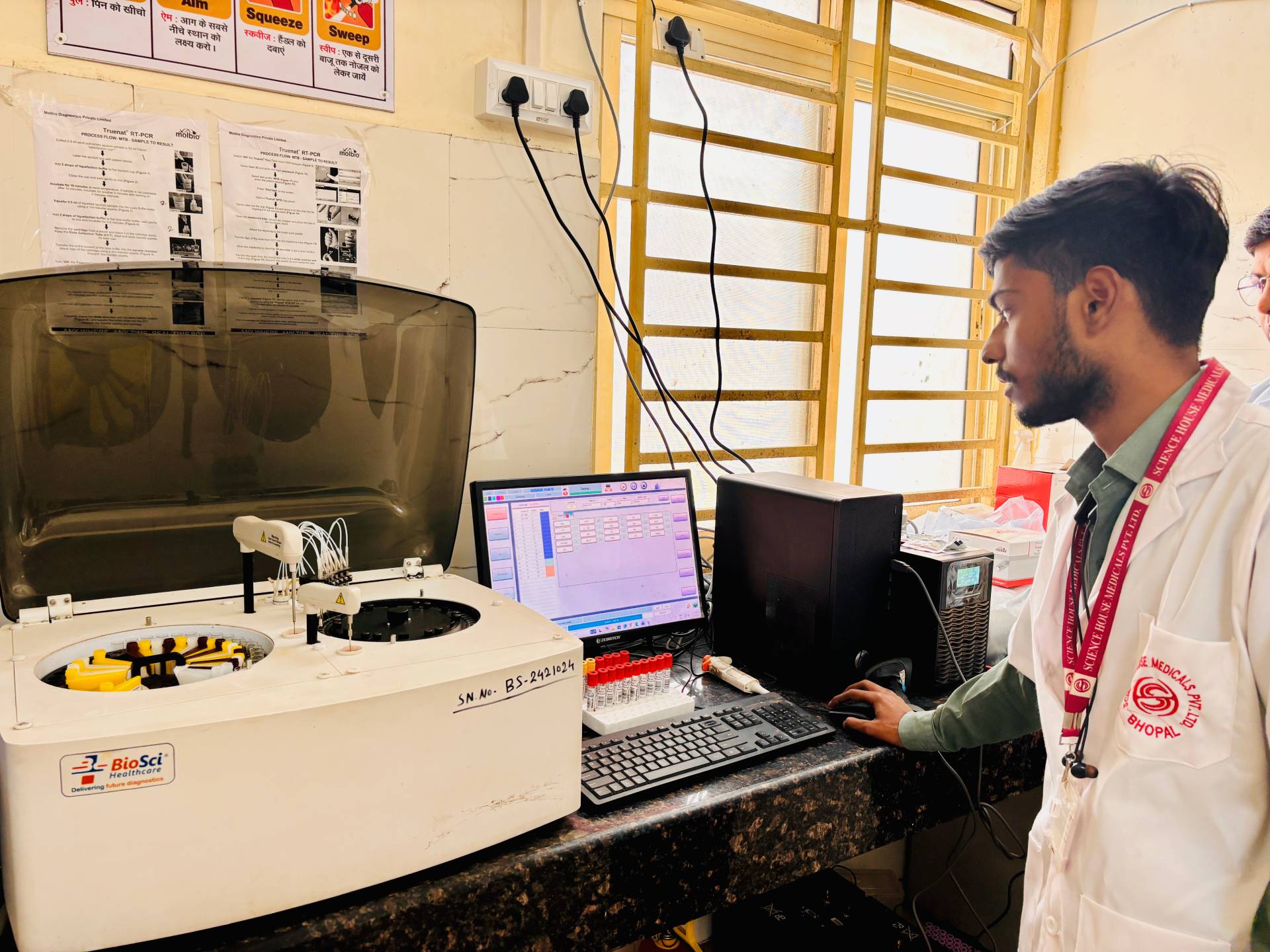 Lab technician uses automated analyzer for fast clinical tests Civil Hospital