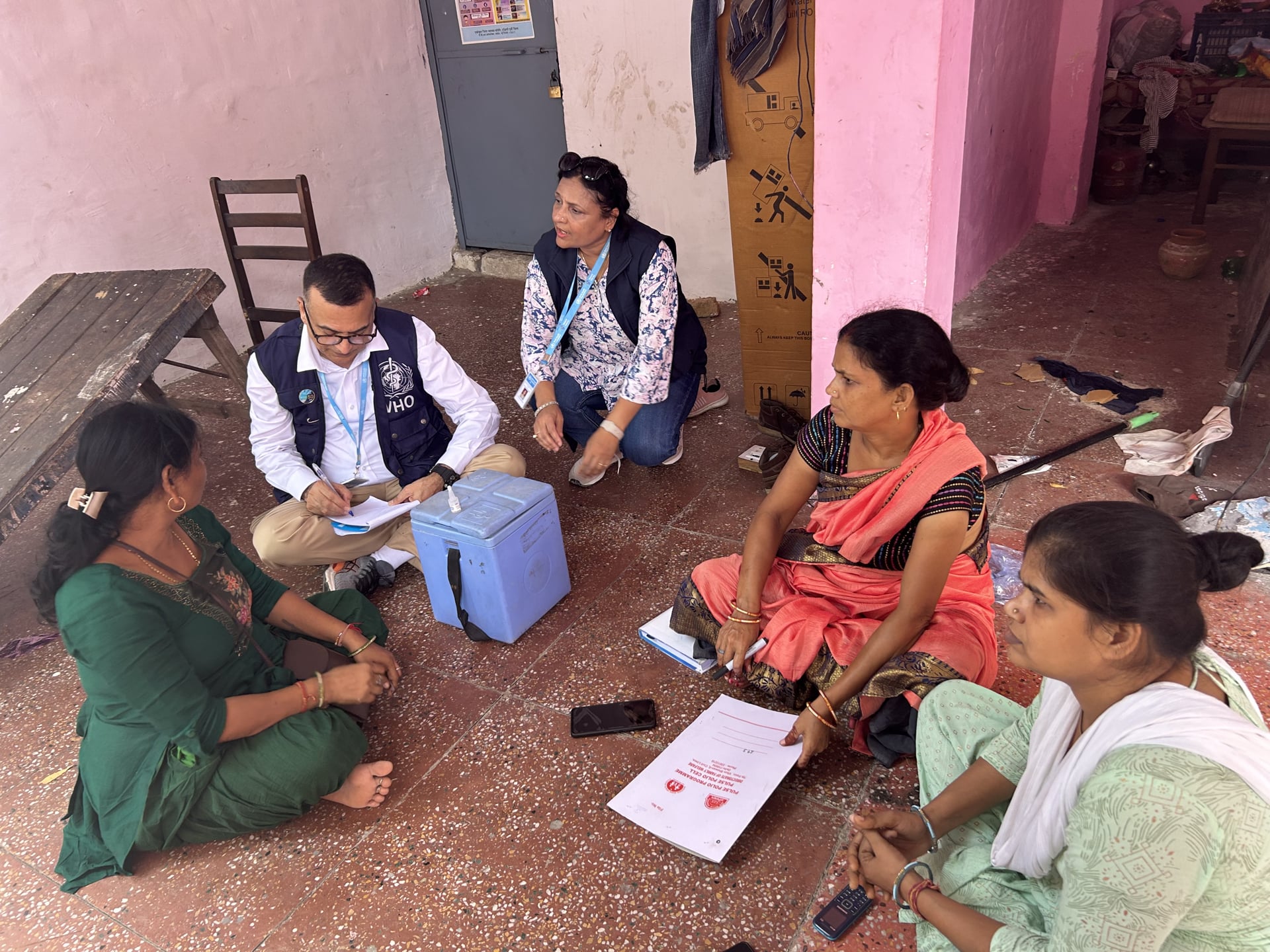 Frontline workers and WHO National Public Health Support Network officers reviewing micro-plans