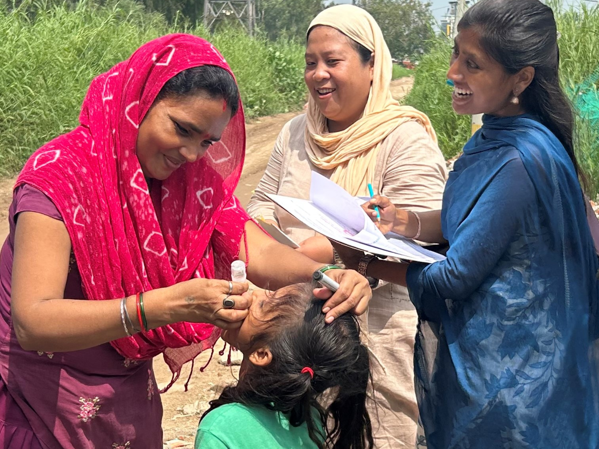 Health and child welfare frontline workers from Polyclinic Madanpur Khadar giving polio drops to a child
