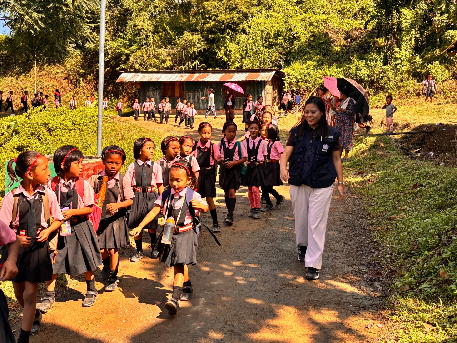 WHO-NPSN staff guiding students at school vaccination site during measles-rubella catch-up campaign.