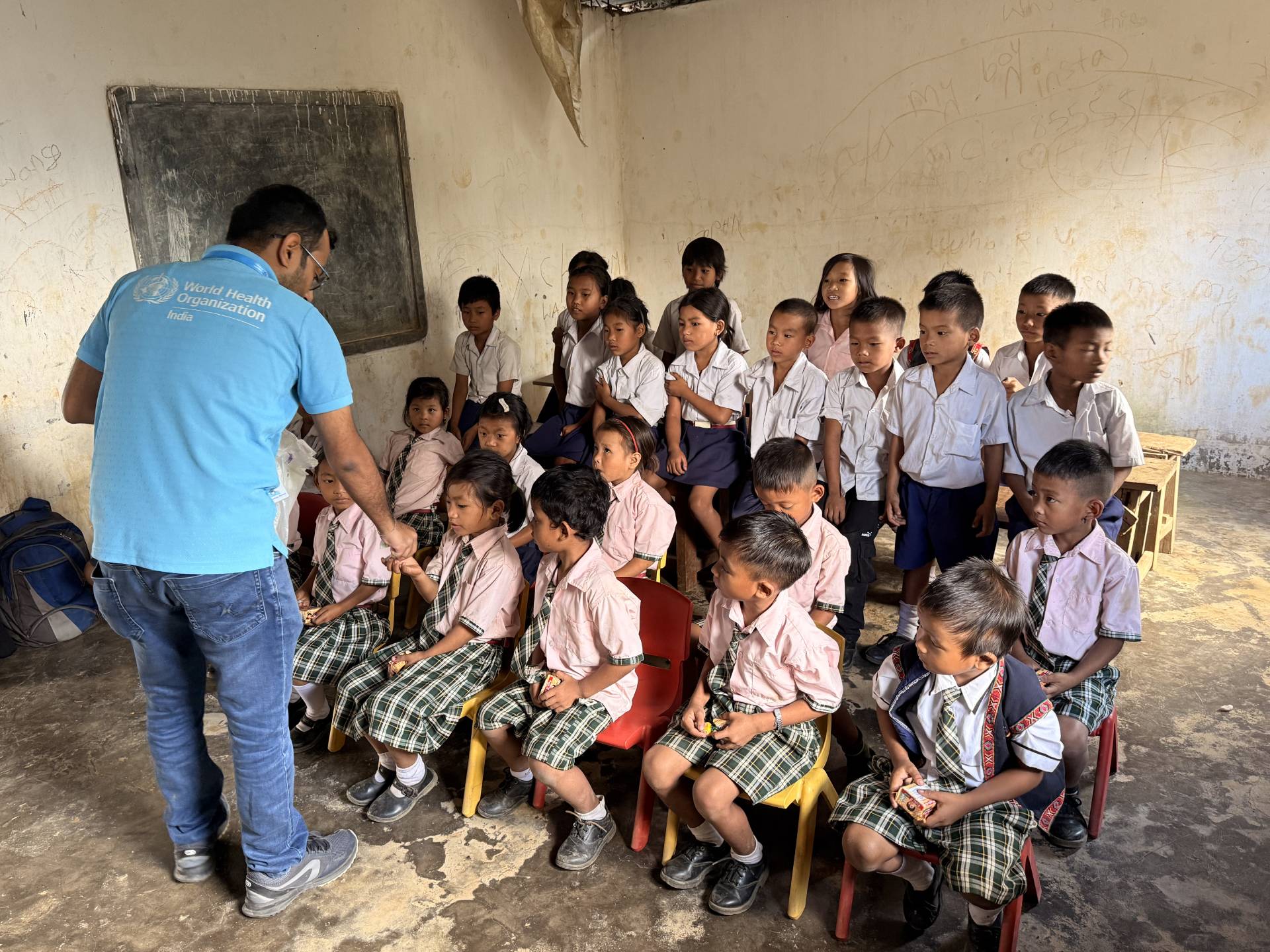 WHO-NPSN personnel engaging with students in observation room after measles-rubella vaccination at Longhua village school.