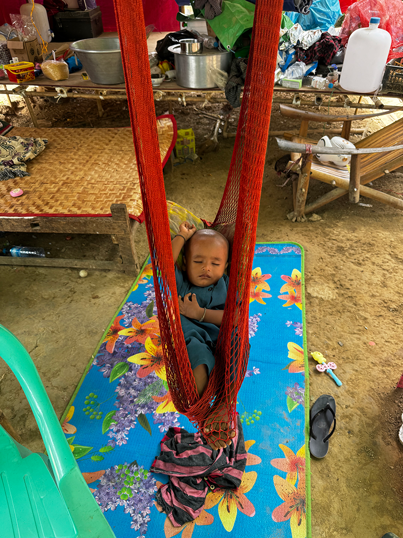 a baby, in their makeshift shelter from Mandalay earthquake relief camp