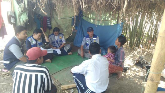 WHO Field Project Coordinator and local health workers engage with villagers during door-to-door malaria testing