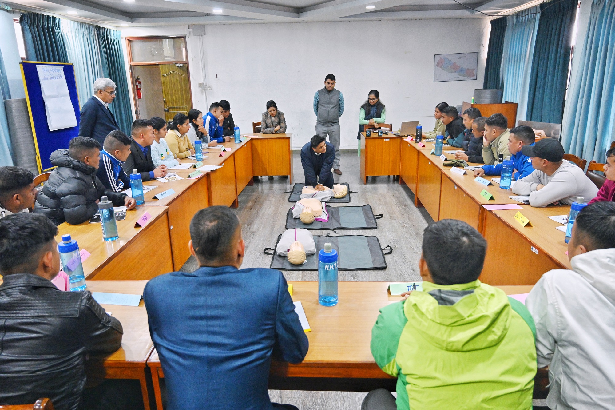 A trainer demonstrates the proper technique for performing Cardiopulmonary Resuscitation (CPR) on a mannequin during a training of trainers session for Community First Health Responders held in Bagmati province, Nepal