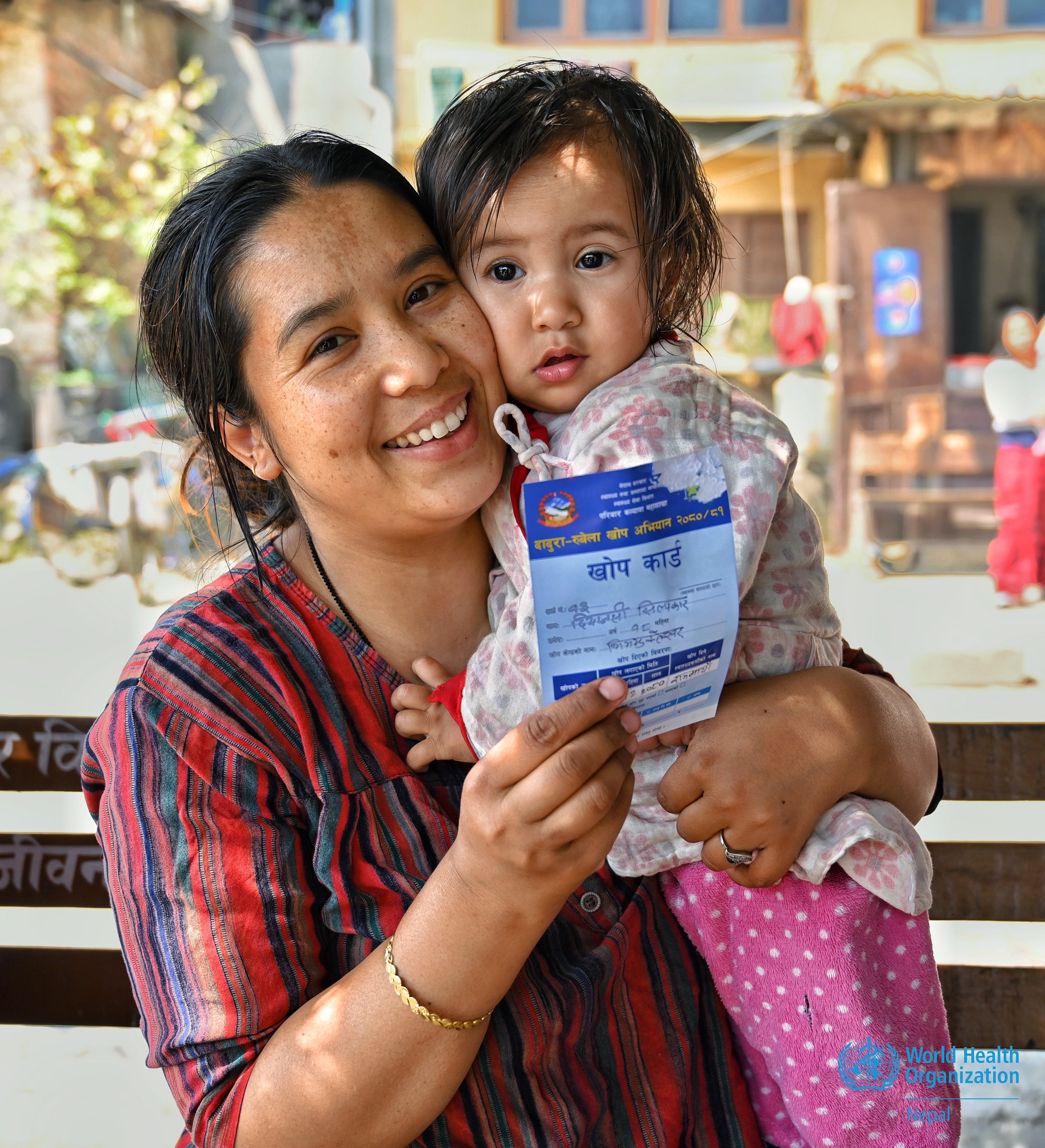 A joyful mother with her child after the child received the measles-rubella vaccine in Bagmati Province, Nepal