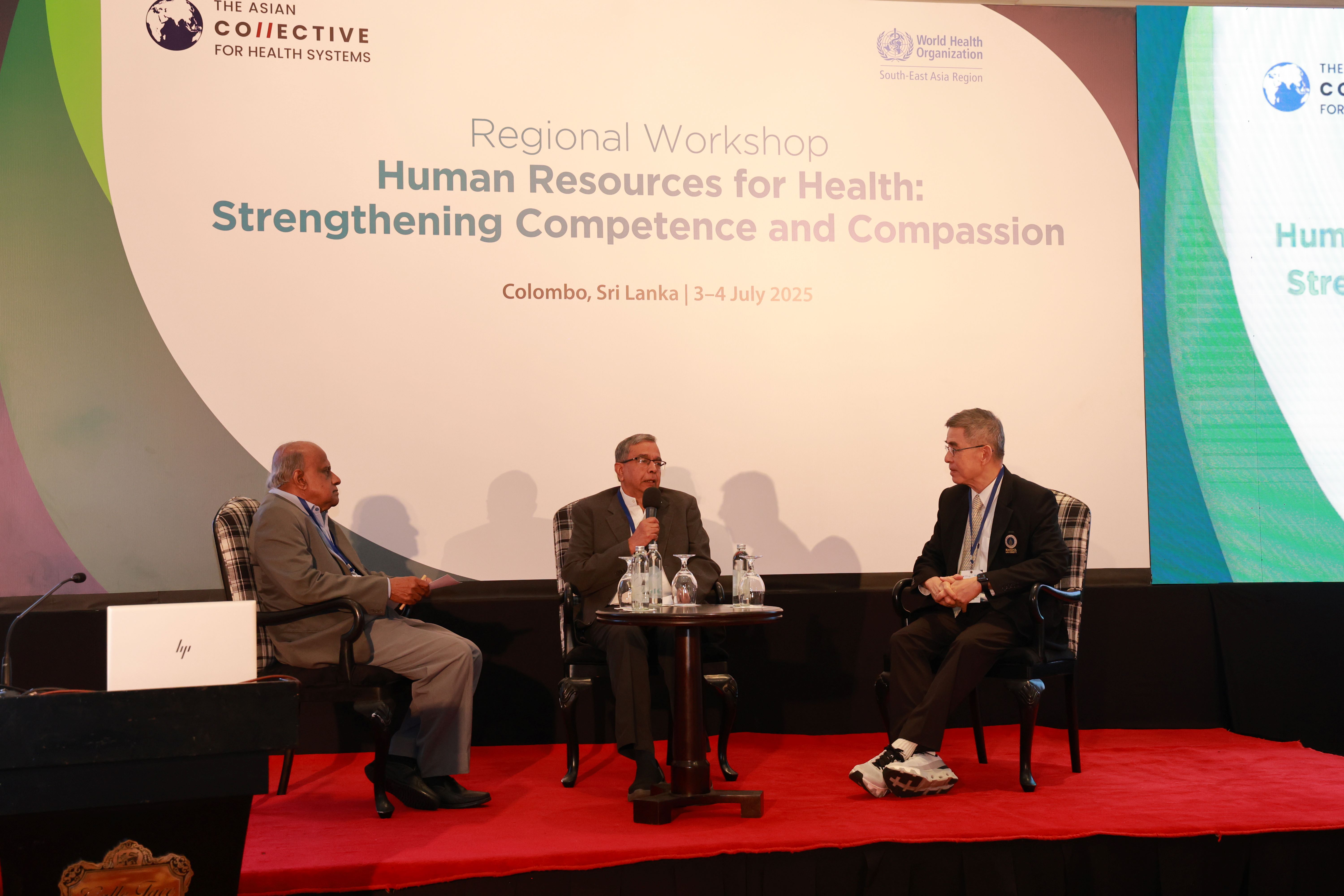 Three people seated on stage at a health workshop in Colombo, with a backdrop showing event details and logos of WHO and The Asian Collaborative for Health Systems.
