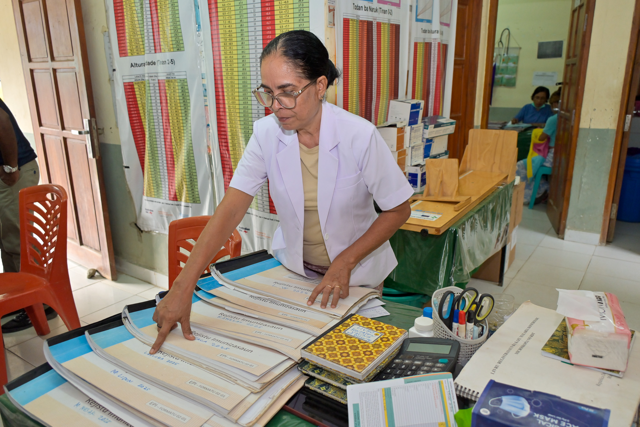 Nurse Hendriqueta at CHC Manleuana showcasing the old immunization ledger