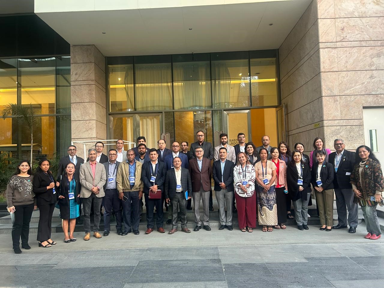 Workshop participants posing together outside a conference venue in New Delhi.