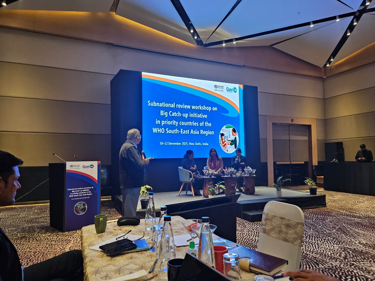 Photograph of a conference room setup for a Subnational review workshop on the Big Catch-up initiative in WHO South East Asia Region, with a large screen displaying the event title and date