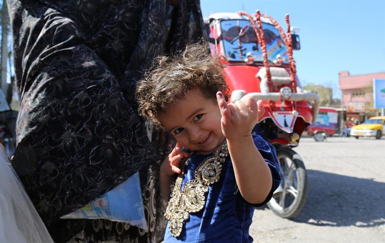 An Afghan girl receives two drops of polio vaccine