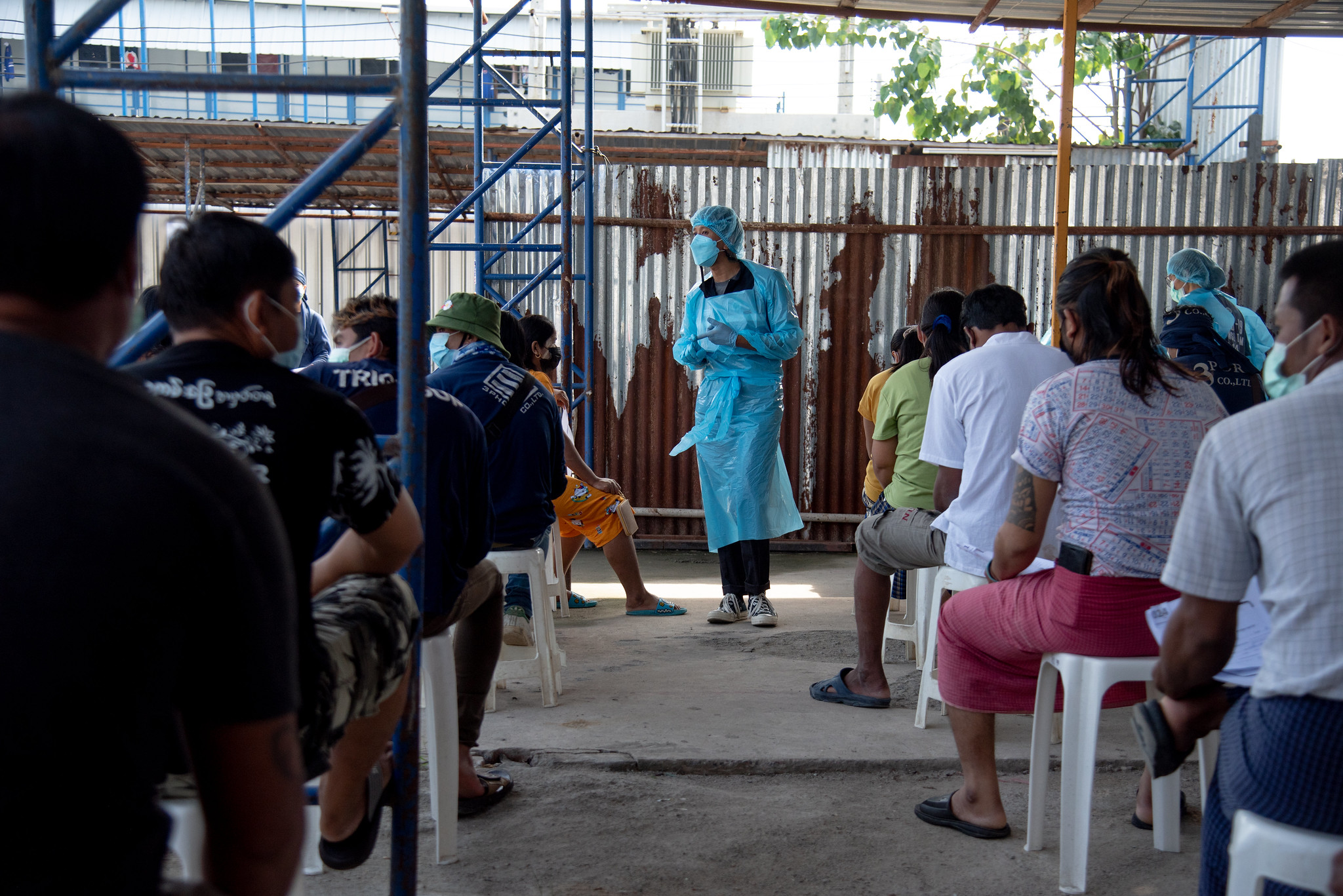 Kyan Thet Khaint, a migrant volunteer, gives COVID-19 information to migrant workers during the waiting time at a migrant labour campsite in Bang Sue, Bangkok – 31st October 2021/ © WHO/Ploy Phutpheng 