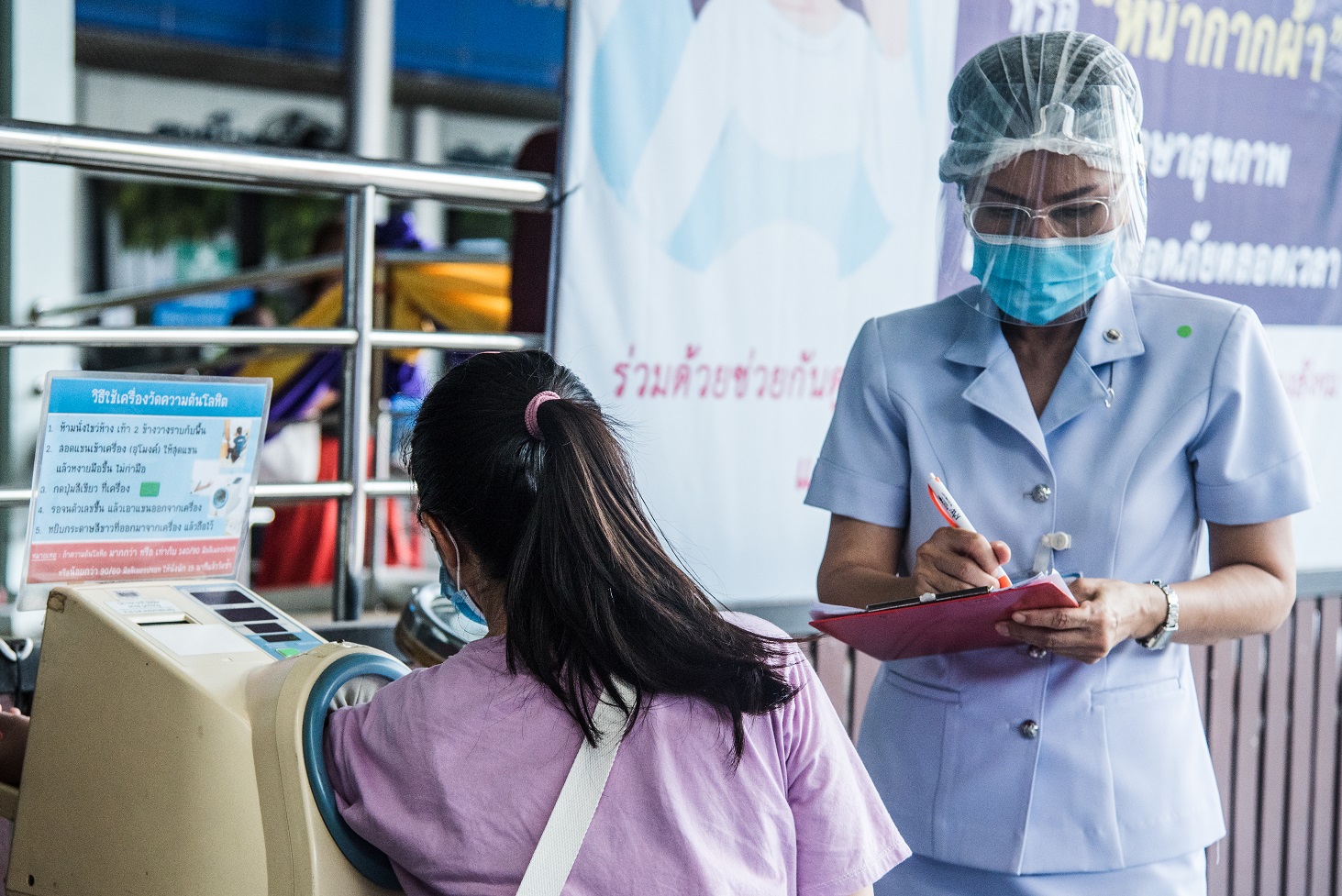 A nurse is filling a health check form at COVID-19 Clinic, Samut Sakhon Hospital to identify the symptoms of the novel coronavirus