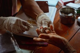 Panaeloi collects blood from the finger of a patient to test for malaria © WHO 2023