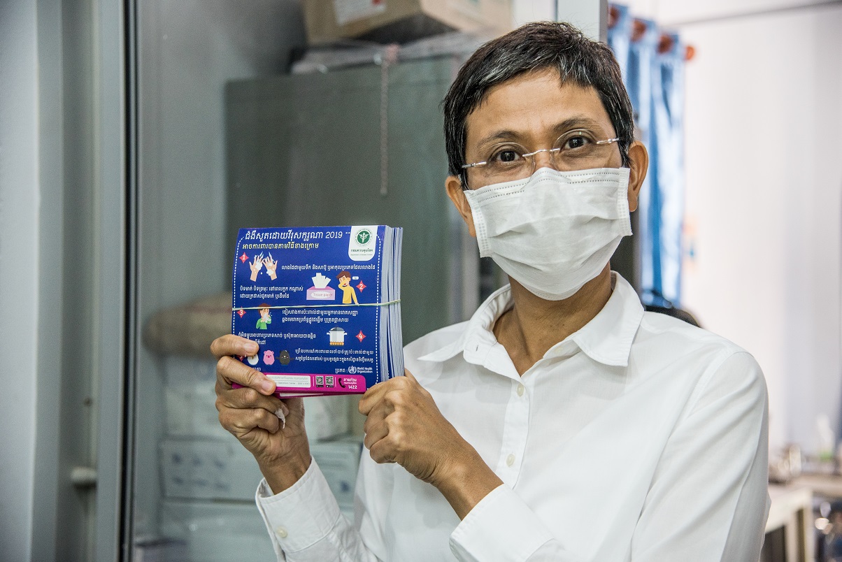A WHO Thailand officer, Aree Moungsookjareoun, shows flyers on COVID-19 prevention that WHO helped produce. A WHO Thailand officer, Aree Moungsookjareoun, shows flyers on COVID-19 prevention that WHO helped produce.