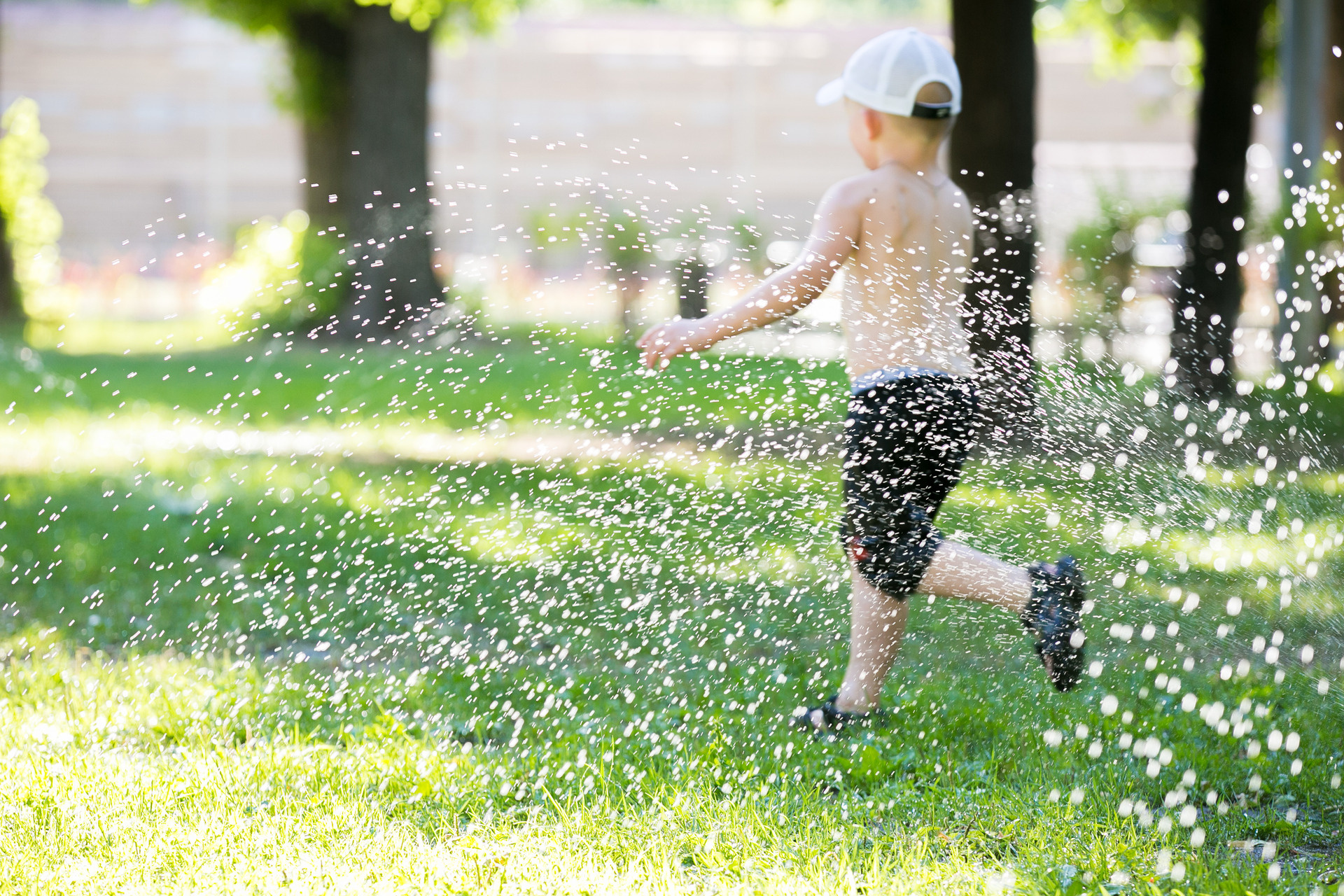 A young boy runs in the grass through sprawing water
