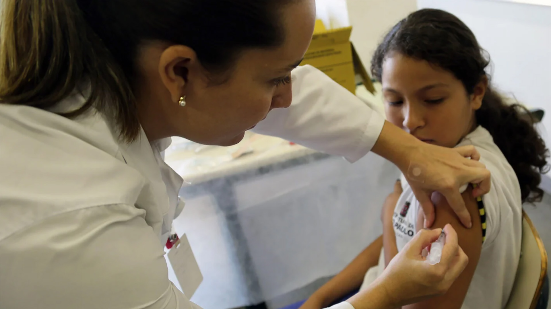Health worker vaccinating a girl