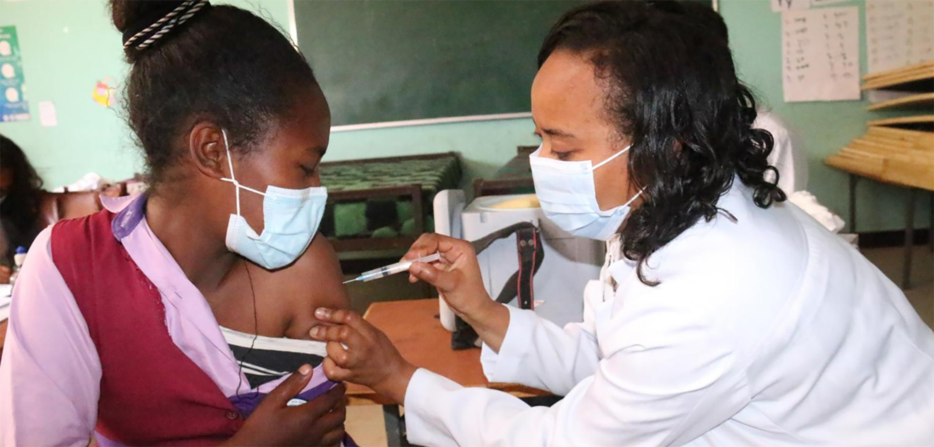 A health worker giving a young girl the HPV vaccine