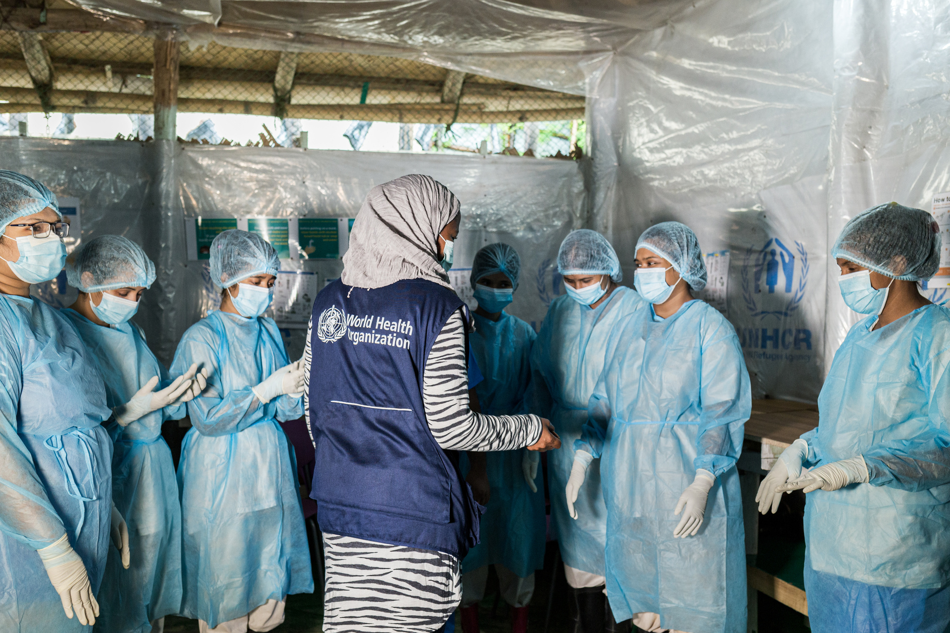 Infection prevention and control specialist (center) advises nurses how to provide safe care for COVID-19 patients