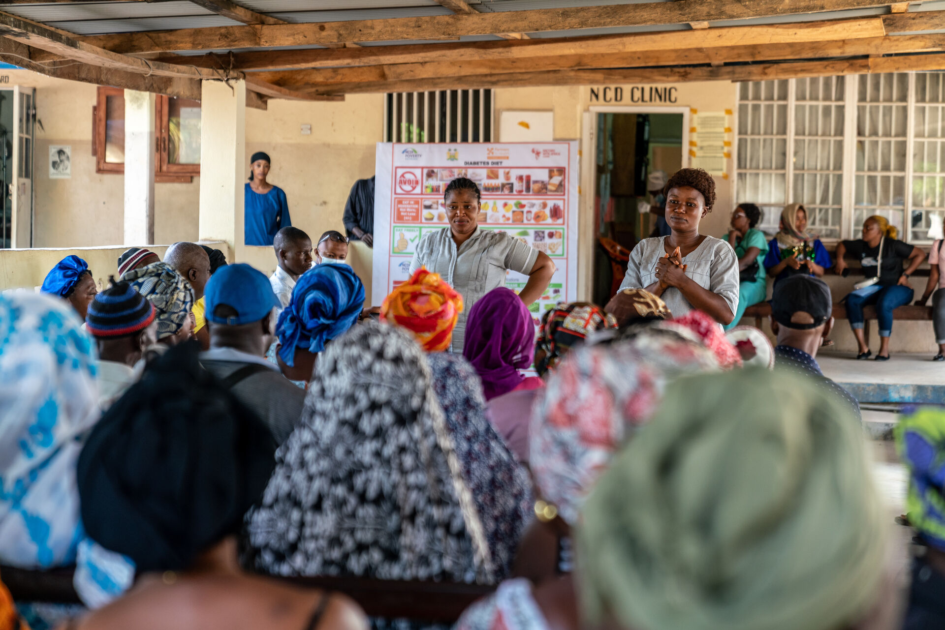 Women presenting to an audience in a room in Sierra Leone