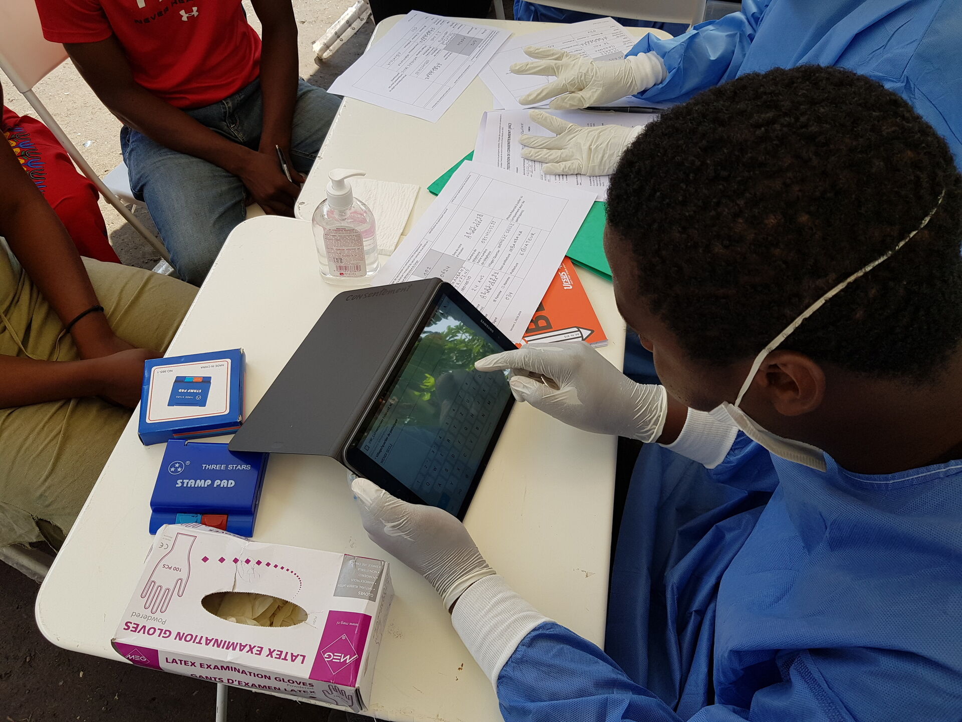 health worker with a mask writing on a tablet