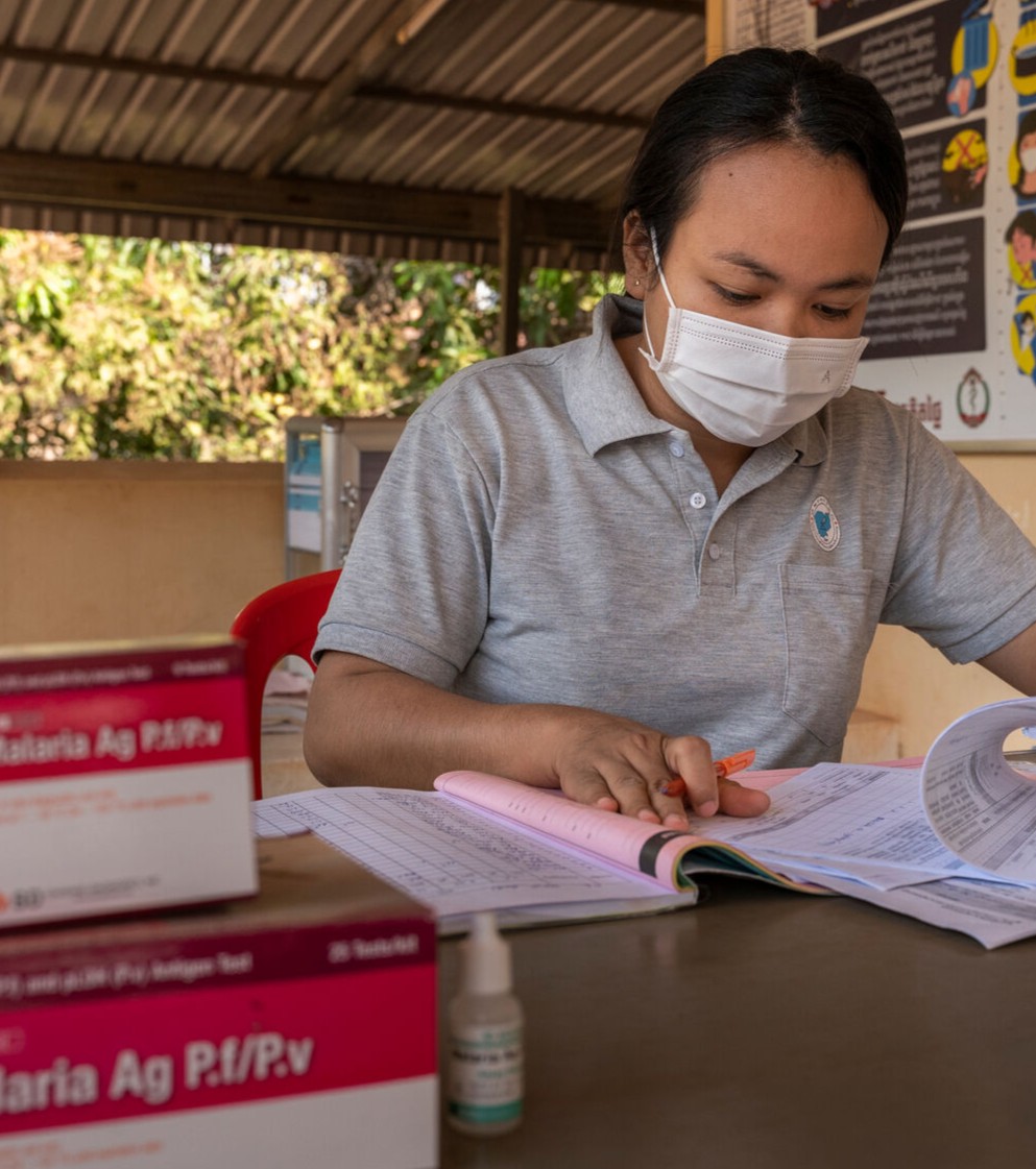 Health worker at a desk with a pen and paper sheets
