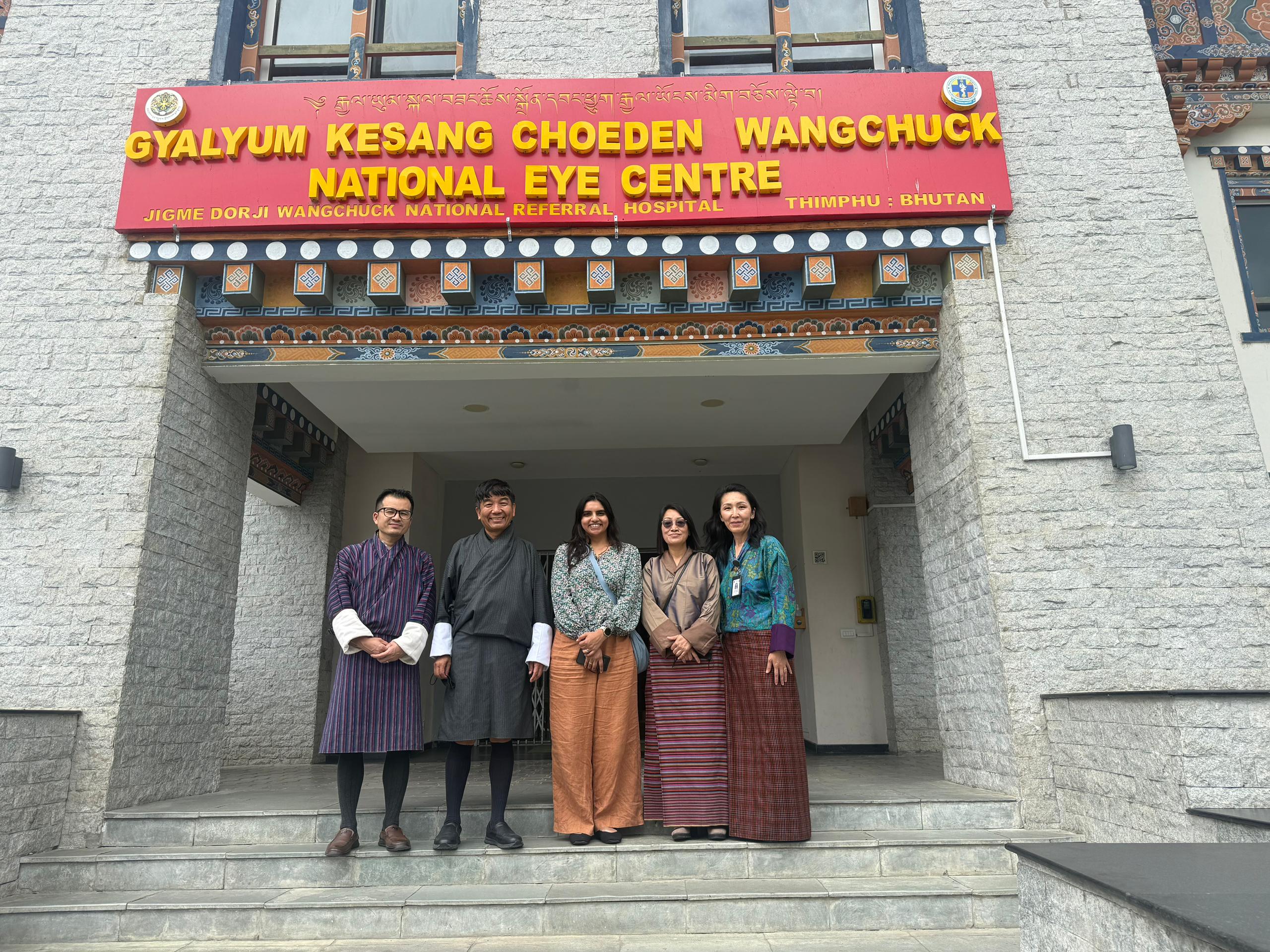 A group of people standing up in front of a building