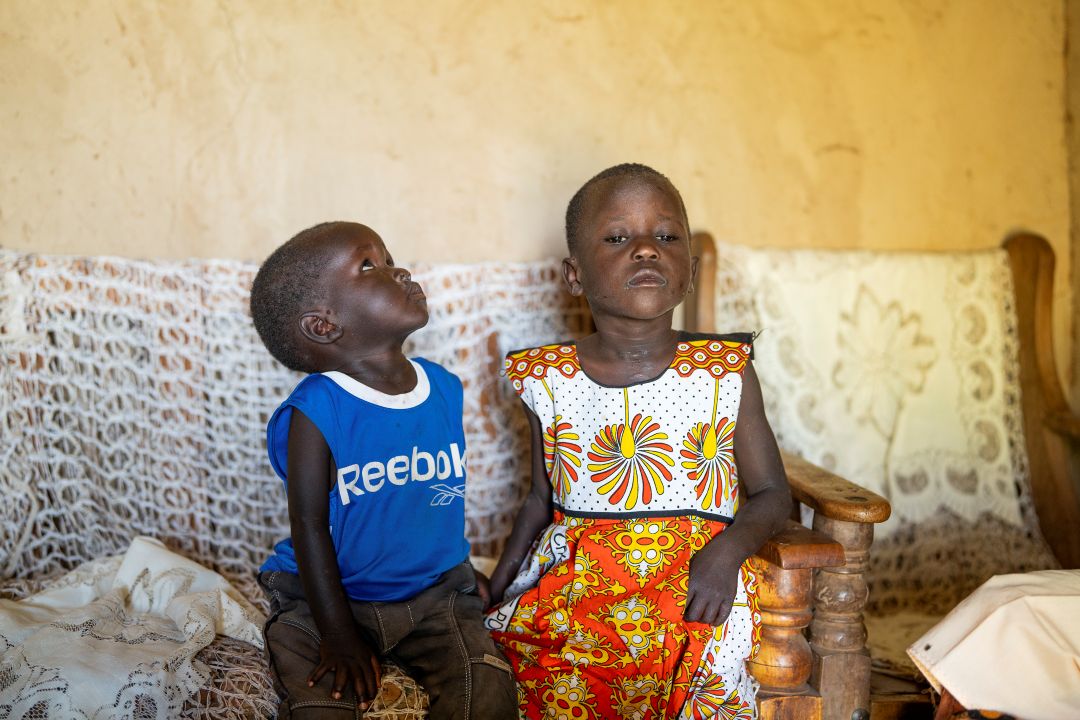 A boy and a girl sitting down on a sofa