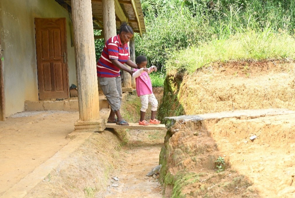 A woman assisting a girl to walk