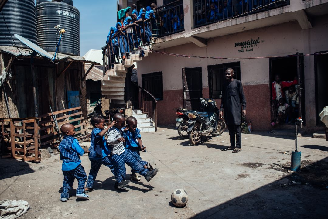 A group of children playing with a football ball outdoors