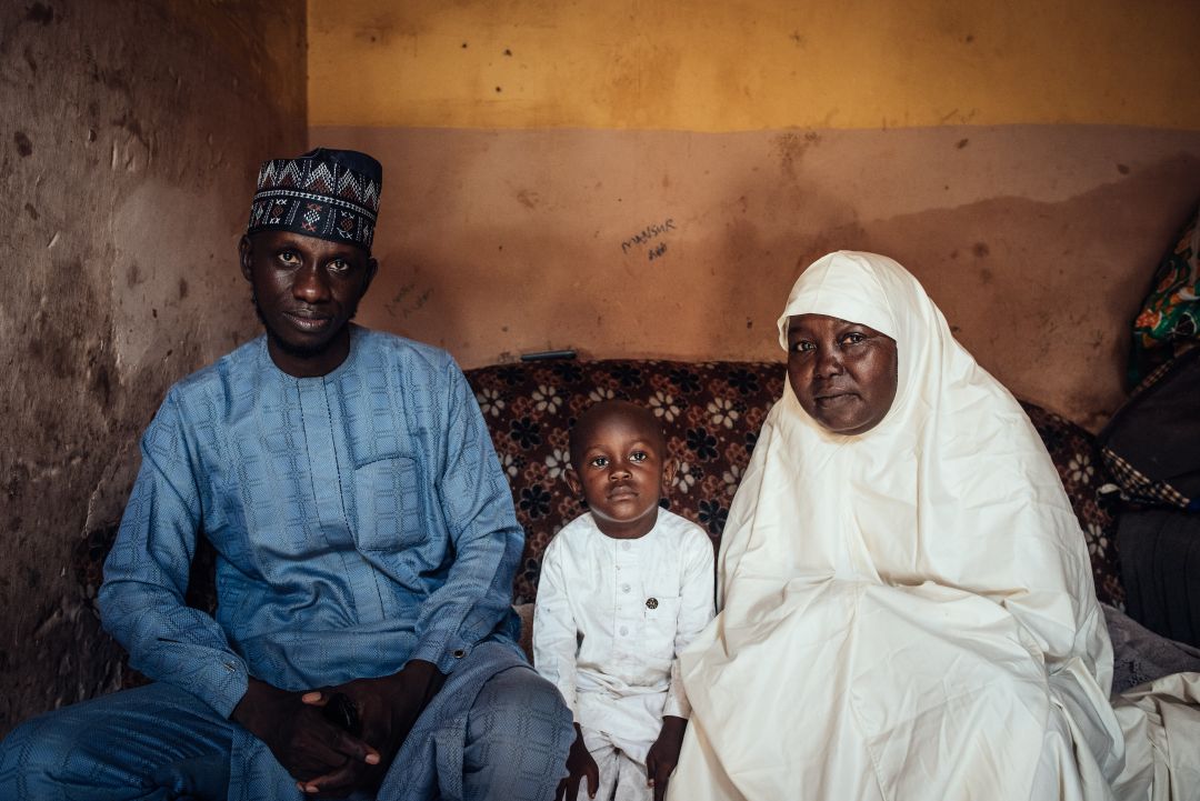 Two adults and a child sitting on a sofa