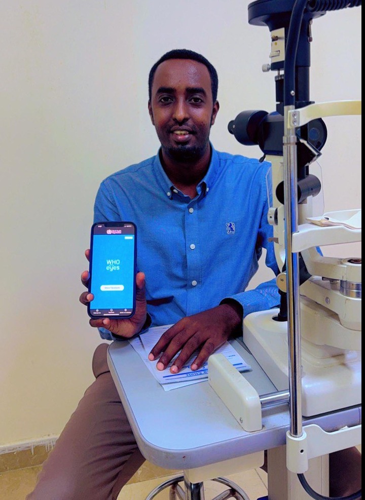 A man holding a mobile phone on his hand , the WHOeyes app is displayed on the screen