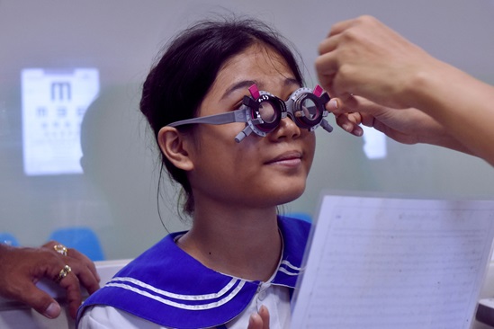 A young girl is trying new reading glasses