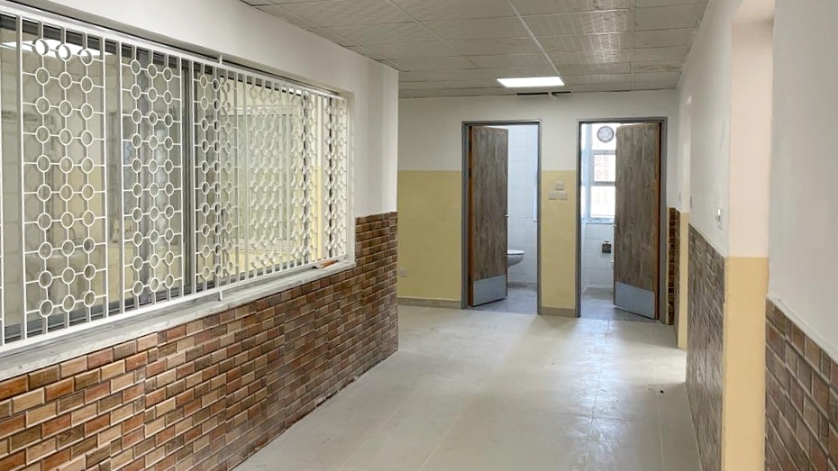 Jordan National Center of Mental Health infrastructure Corridor view of a facility showing a large window with metal bars and two toilets further down the hall.