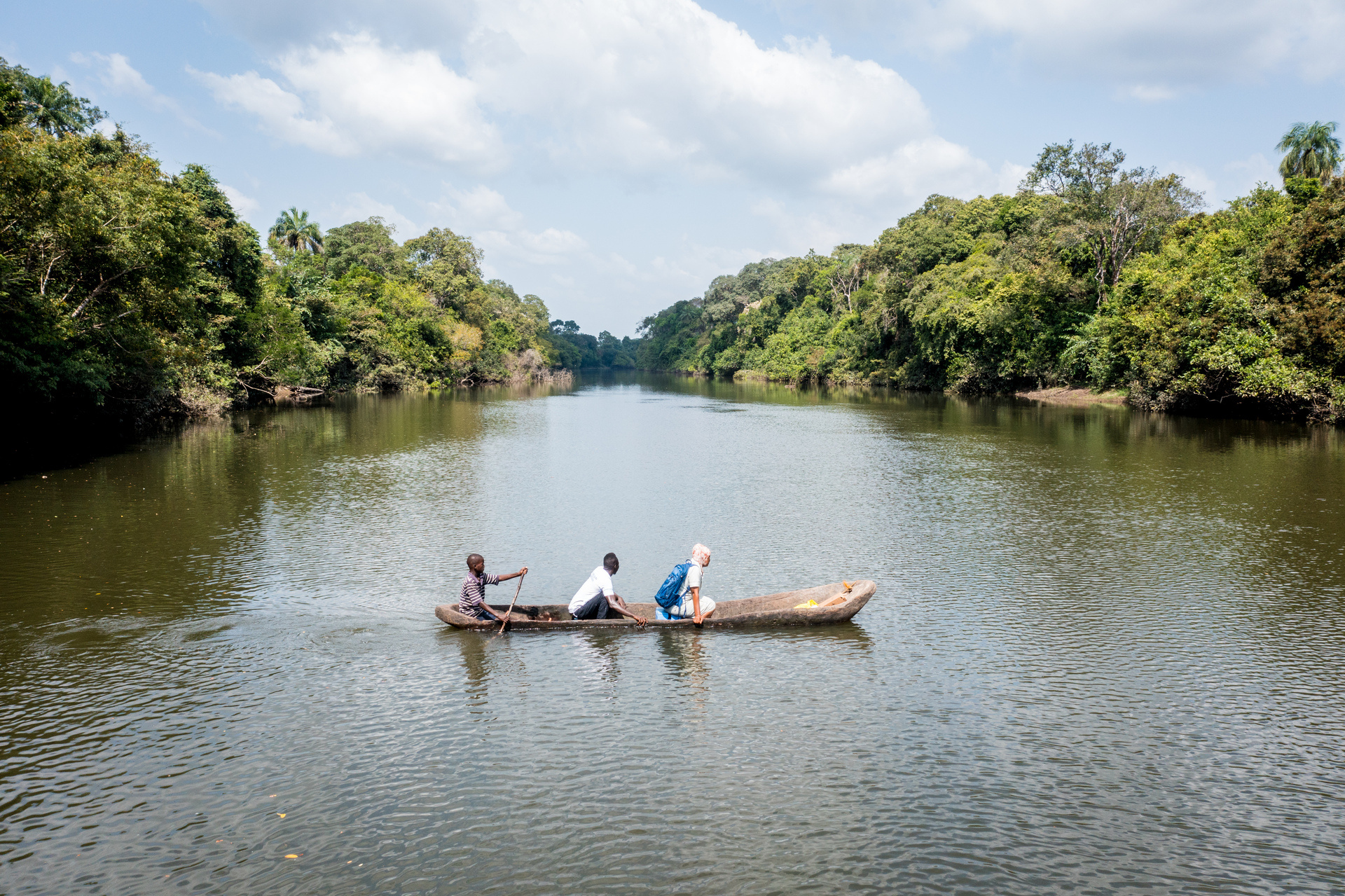 three people crossing the river by canoe three people crossing the river by canoe